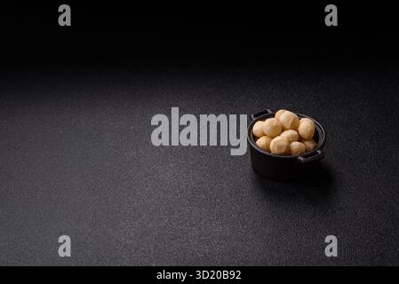 Noix de macadamia pelées crues dans un bol en céramique Banque D'Images