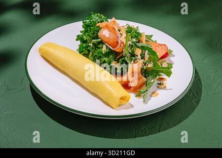 Délicieuse omelette servie avec une salade fraîche au chou frisé et au saumon fumé dans un cadre confortable Banque D'Images
