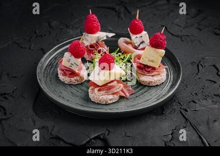 Délicieux canapés servis sur une assiette élégante avec garnitures et garnitures assorties Banque D'Images