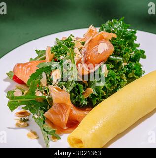 Délicieuse omelette servie avec une salade fraîche au chou frisé et au saumon fumé dans un cadre confortable Banque D'Images