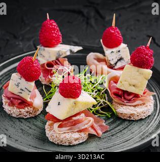 Délicieux canapés servis sur une assiette élégante avec garnitures et garnitures assorties Banque D'Images