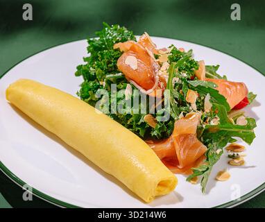 Délicieuse omelette servie avec une salade fraîche au chou frisé et au saumon fumé dans un cadre confortable Banque D'Images