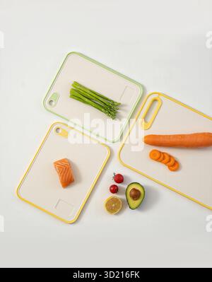 Ingrédients crus frais sur planche à découper jaune, y compris saumon avocat légumes de bœuf et fruits fond blanc photo stock Banque D'Images