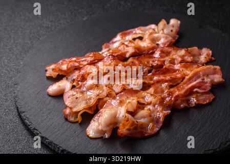 Bacon croustillant cuit, tranches de porc rôti pour un petit déjeuner anglais. Bacon frit Banque D'Images