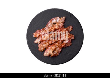 Bacon croustillant cuit, tranches de porc rôti pour un petit déjeuner anglais. Bacon frit Banque D'Images