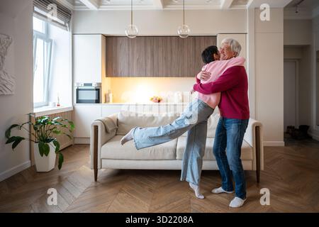 Femme mature ravie de courir dans les bras de mari câlin. Célébration de couple senior, heureuse réunion de famille Banque D'Images