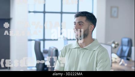 Homme indien barbu debout portant une chemise verte dans un espace de bureau, avec fenêtre de grille et lampe en laiton Banque D'Images
