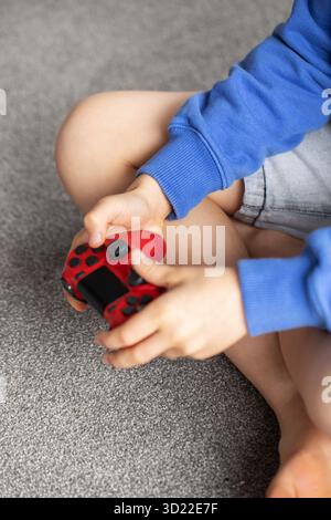 Gros plan des mains d'un garçon tenant une manette de jeu. Jeux vidéo, consoles de jeux. Banque D'Images