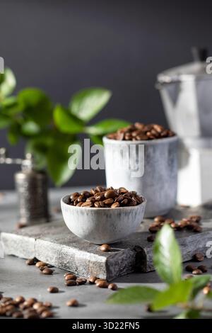 Une poignée de grains de café torréfiés à Minsk sur fond gris. Banque D'Images