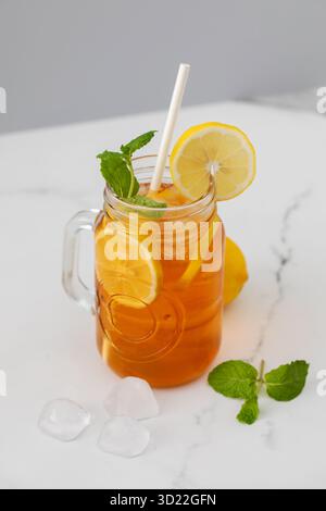 Un verre avec une boisson fraîche d'été. Thé glacé avec citron et menthe. Banque D'Images