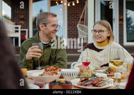 Homme d'âge moyen caucasien et sa fille appréciant le dîner en plein air Banque D'Images
