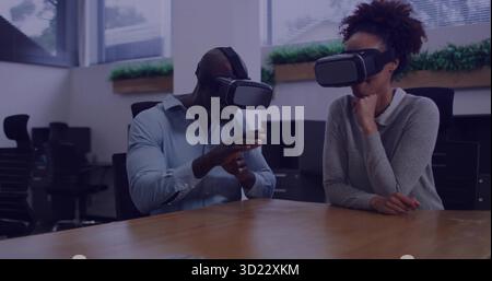 Test du logiciel VR par deux collègues portant des casques dans une salle de conférence moderne, montrant le feuillage Banque D'Images