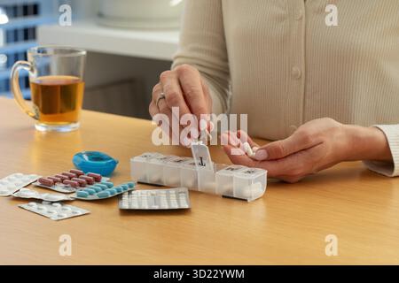 Organisation quotidienne des médicaments avec boîte à pilules et comprimés sur table en bois. Les soins de santé Banque D'Images