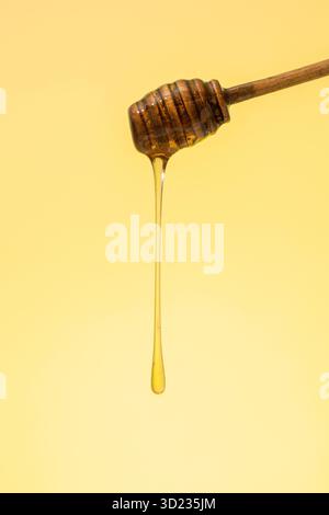 Miel doré coulant d'une benne en bois. Banque D'Images