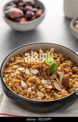 Granola maison croustillant avec des amandes tranchées dans un bol. Nourriture saine Banque D'Images