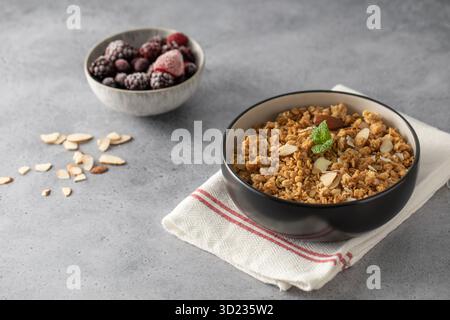 Granola maison croustillant avec des amandes tranchées dans un bol. Nourriture saine Banque D'Images