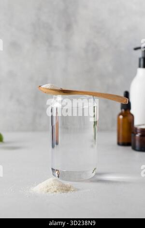 Un verre d'eau, une lame de poudre de collagène, des cosmétiques de soin. Procédures anti-âge, suppléments nutritionnels pour la santé Banque D'Images