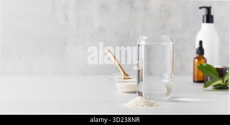 Un verre d'eau, une lame de poudre de collagène, des cosmétiques de soin. Procédures anti-âge, suppléments nutritionnels pour la santé Banque D'Images