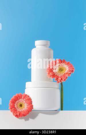 Mockup est un pot blanc avec des pilules ou des vitamines sur un podium. Vitamines pour femmes Banque D'Images