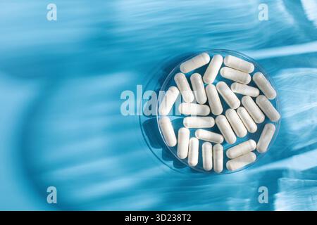 Capsules médicinales blanches, vitamines ou compléments alimentaires en gros plan. Médecine. Espace de copie Banque D'Images