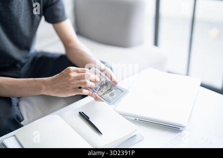 Homme calculer argent billets de banque finances épargne économie maison payer factures impôts financiers à la maison Banque D'Images