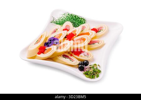 Un hors-d'œuvre élégant composé de petits rouleaux de crêpes fourrés de saumon fumé, de fromage à la crème et d'herbes, garni de caviar rouge et Banque D'Images