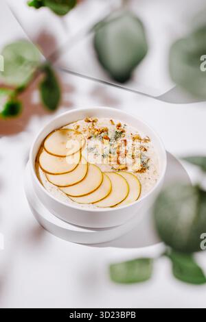 Bol de flocons d'avoine sain garni de tranches de pommes et de granola pour le petit déjeuner Banque D'Images
