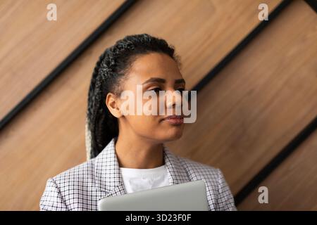 Portrait d'une femme d'affaires multiethnique heureuse utilisant une tablette numérique dans une agence. Banque D'Images