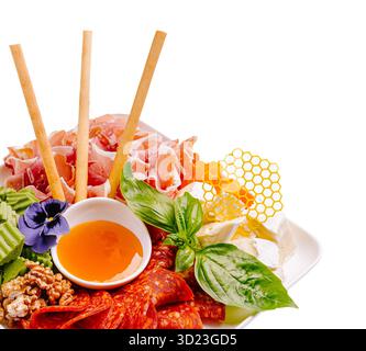 Magnifique plateau gastronomique de viandes variées, fromages et nid d'abeilles Banque D'Images