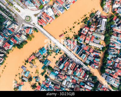 Vue aérienne d'une zone urbaine inondée avec rivière boueuse et toits colorés. CAO Bang ville, Cao Bang, Vietnam Banque D'Images
