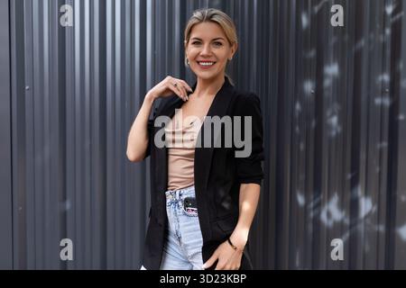 Portrait d'une élégante femme d'âge moyen dans un costume d'affaires sur le fond d'un mur en relief dans le bureau Banque D'Images