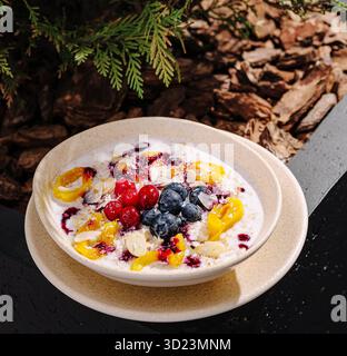 Bol de fruits frais garni de baies et de yaourt servi à l'extérieur Banque D'Images