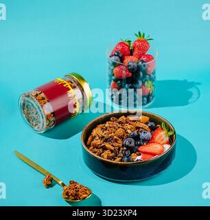 Petit déjeuner coloré avec granola et fruits frais sur un fond lumineux Banque D'Images