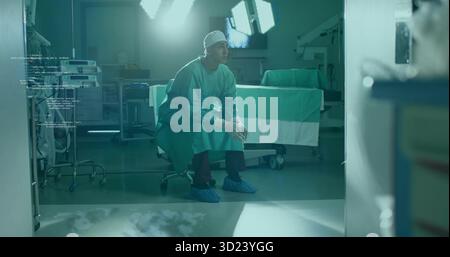 Chirurgien penchant serrant les mains sur les selles dans les frottements au BLOC OPÉRATOIRE, avec des lampes chirurgicales et des moniteurs Banque D'Images