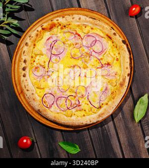 Délicieuse pizza maison garnie de fromage, jambon et oignons sur une table en bois Banque D'Images