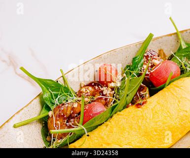 Omelette aux épinards avec tomates fraîches et garnitures croquantes servies Banque D'Images