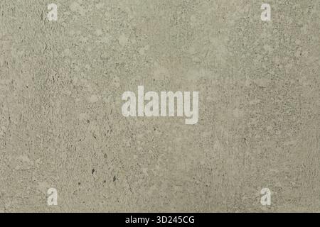 Mur en béton texturé avec de subtiles variations de couleur et de motif vu de près pendant la lumière du jour dans un cadre extérieur Banque D'Images