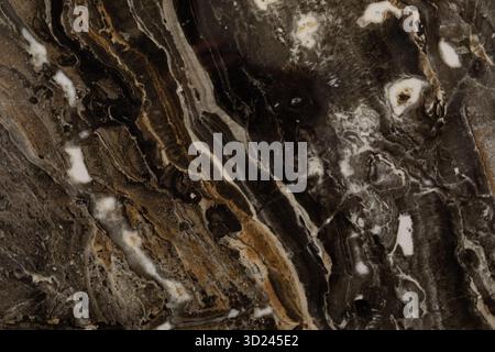 Texture de pierre naturelle avec des motifs tourbillonnants et des couleurs terreuses trouvées dans les formations géologiques Banque D'Images
