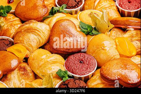 Une vivacité de pâtisseries variées et de délices cuits au four, avec des croissants, des biscuits en forme de cœur et des desserts colorés, le tout magnifiquement arrangé Banque D'Images