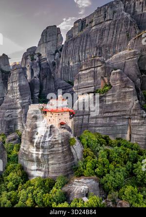 Vue aérienne du monastère de Rousanou perché au sommet d'un pilier monolithique, son toit en tuiles rouges contraste vibrant avec les rochers gris, Kalabaka, Trikala, Banque D'Images