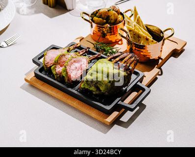 Délicieuses côtelettes d'agneau servies avec accompagnements dans un cadre élégant Banque D'Images