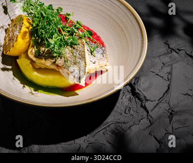 Plat de poisson délicieusement plaqué garni d'herbes et de citron sur une vaisselle élégante Banque D'Images