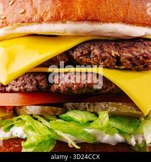 Le double cheeseburger est empilé haut avec deux galettes de bœuf, du fromage fondu et des légumes frais. Les couleurs éclatantes soulignent la fraîcheur du Banque D'Images