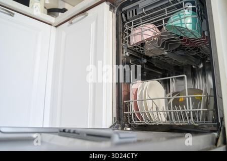 Lave-vaisselle ouvert avec vaisselle propre et tasses dans le cadre moderne de la cuisine Banque D'Images