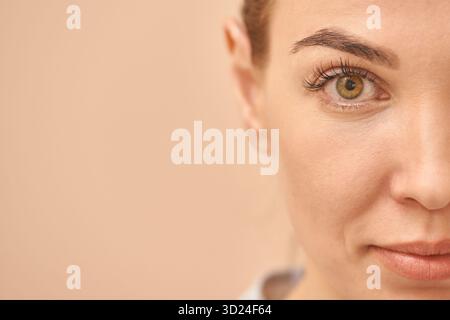 Visage partiel de jeune femme caucasienne avec oeil concentré et maquillage naturel Banque D'Images