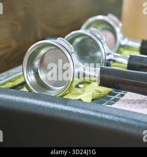 Gros plan des portafilters de machine à espresso sur le comptoir avec fond en bois Banque D'Images