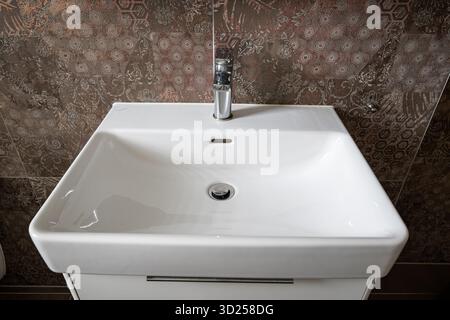 Salle de bains moderne sqare lavabo ou lavabo et robinet d'eau chromé. Grand angle, vue de haut en bas, mur carrelé en arrière-plan, pas de personnes Banque D'Images