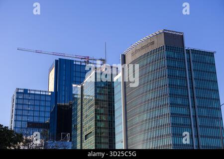 Poznan, Pologne - 24 septembre 2025 : les immeubles de bureaux en verre reflètent le ciel bleu, avec une grue, signifiant le développement urbain et la croissance future Banque D'Images