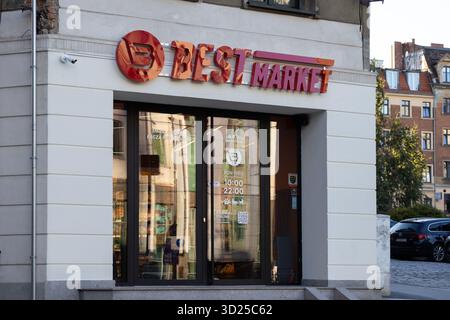 Poznan, Pologne - 24 septembre 2025 : L'entrée accessible du supermarché BEST MARKET présente une marque rouge et des portes vitrées, mettant en valeur le commerce de détail urbain an Banque D'Images