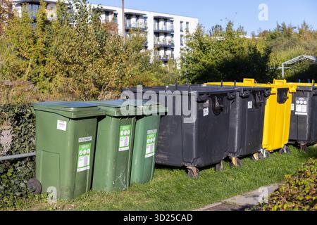 Poznan, Pologne - 24 septembre 2025 : bacs extérieurs verts, noirs, jaunes pour le recyclage trié, montrant l'engagement urbain envers la protection de l'environnement et Banque D'Images